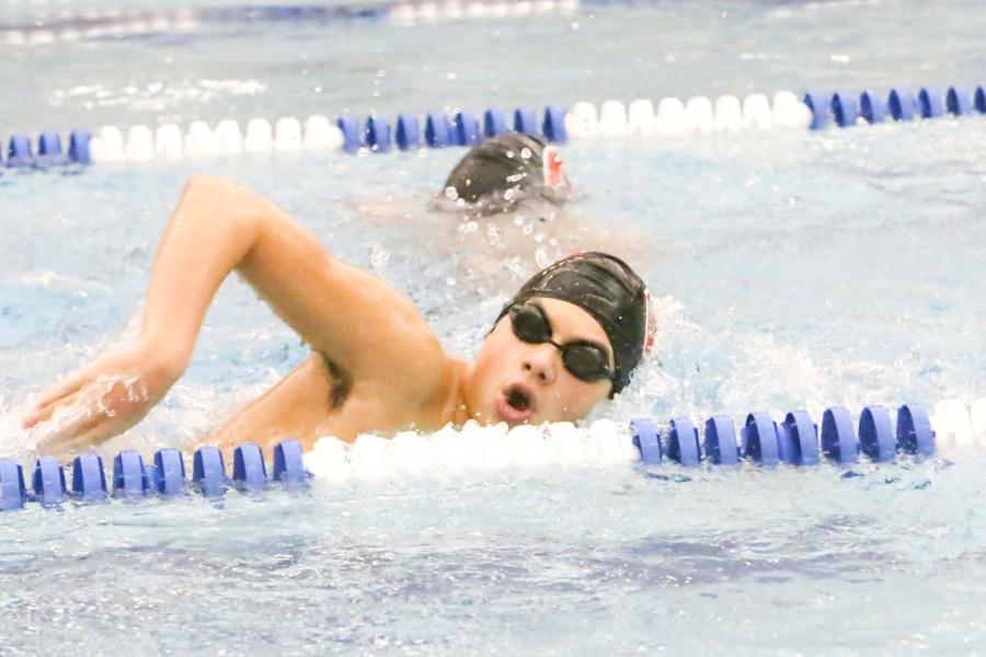 Junior Ryan Kay takes a breath of air as he continues to swim his race.