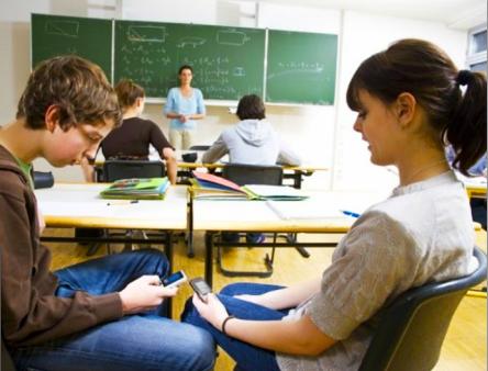 Non-CHS students text during a class when the teacher is commanding the room at the front of class.