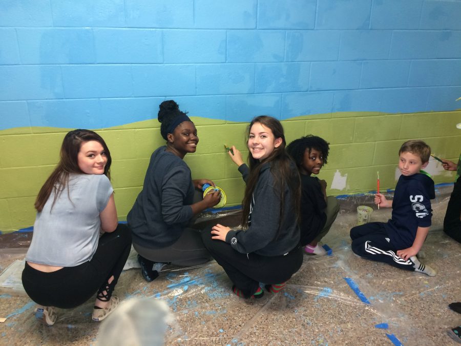 Seniors Brianna Wolbert, Prisca Blamon (center) and Andrea Benites (right) work on the mural with some members of New Albany school.
