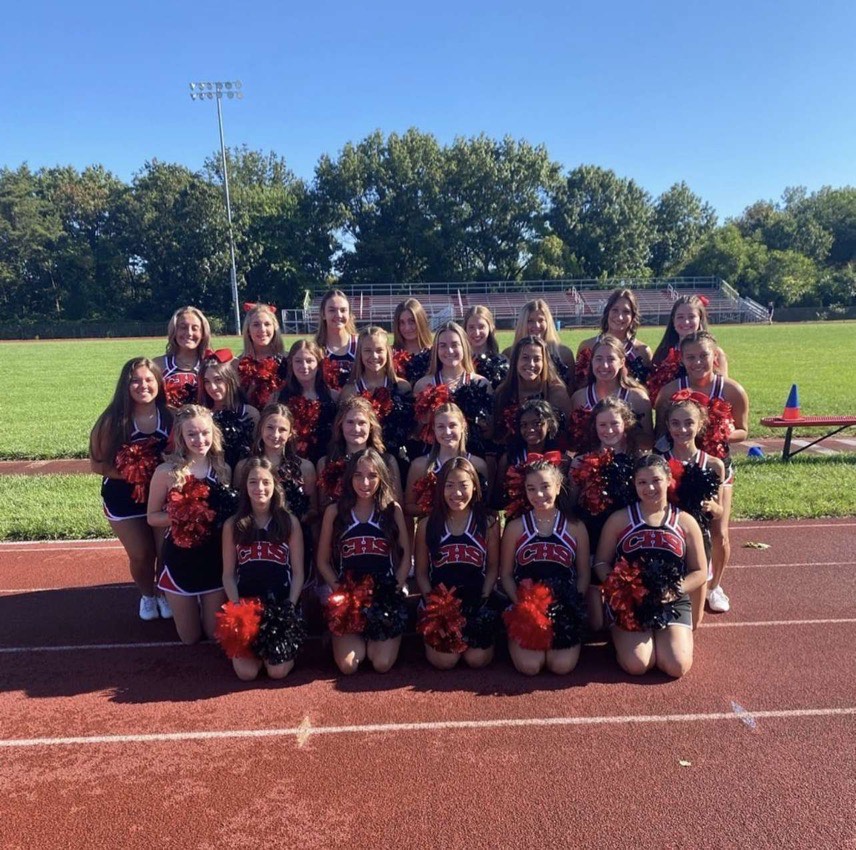 The cheer team poses for a picture by the CHS football field. (photo courtesy of Whitney Nguyen and CHS Cheerleading) 