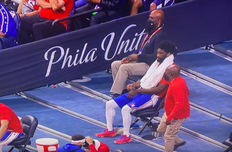 Officer Rogers sits next to Philadelphia 76ers Joel Embiid, working as player security. Photo courtesy of Officer Rogers