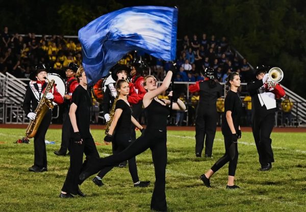 (Photo Courtesy of Nick DeCesare) Color guard and marching band work together to perform during half time.