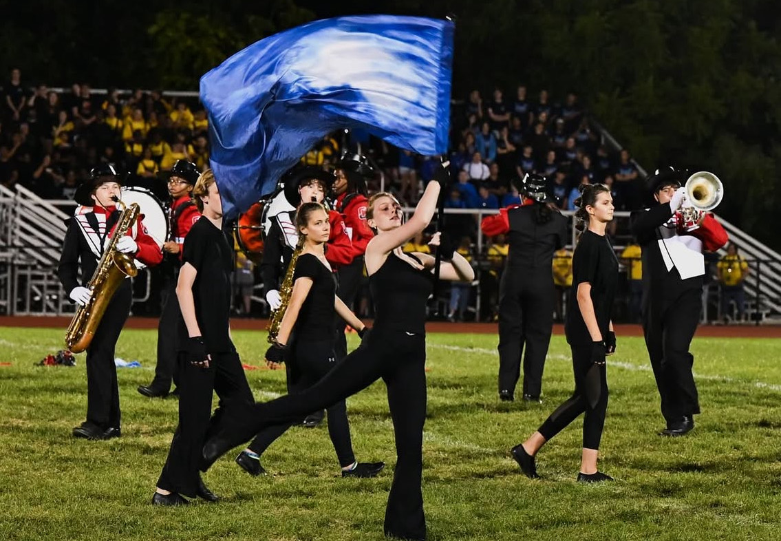 (Photo Courtesy of Nick DeCesare) Color guard and marching band work together to perform during half time.